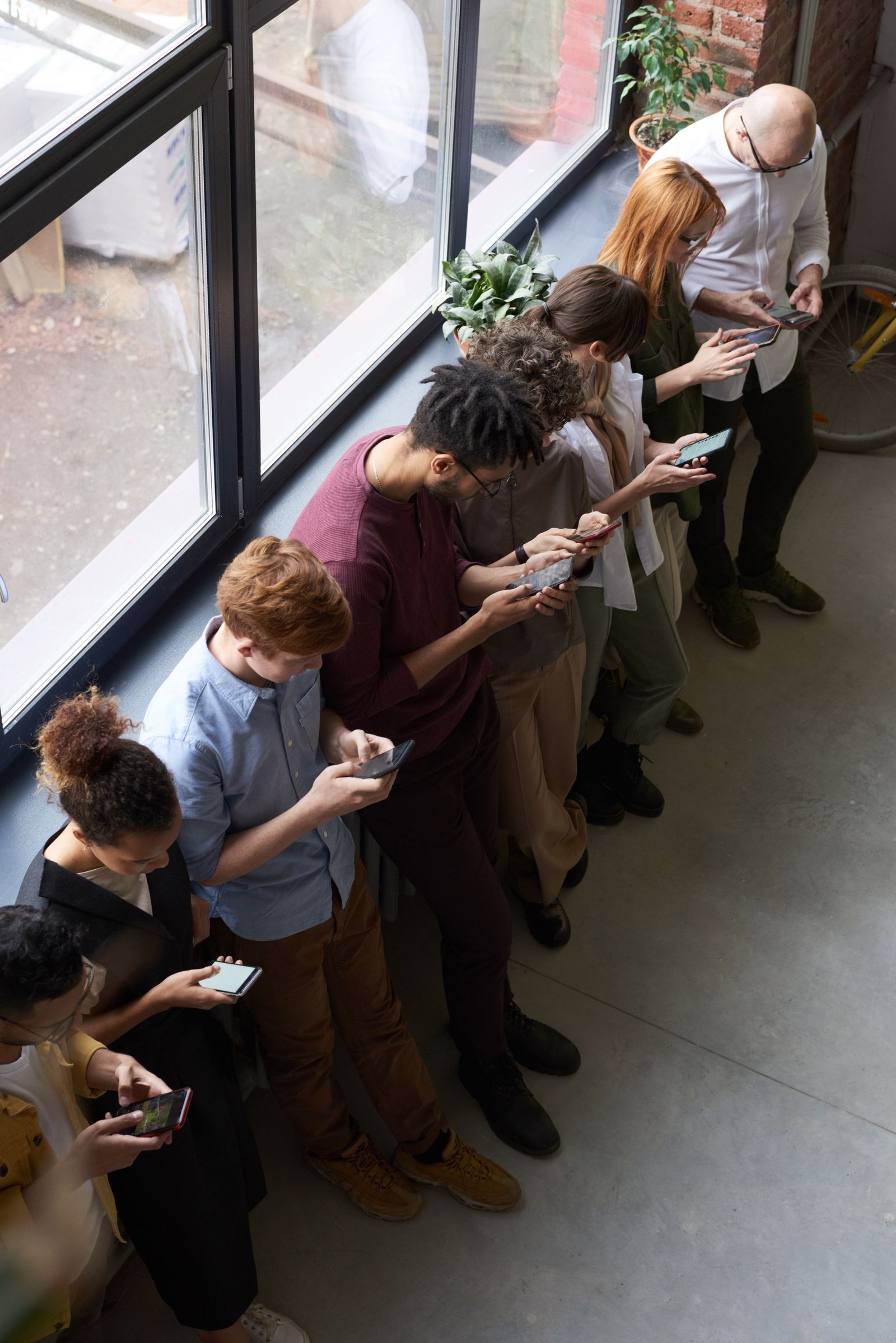 A diverse group of people using their phones and devices